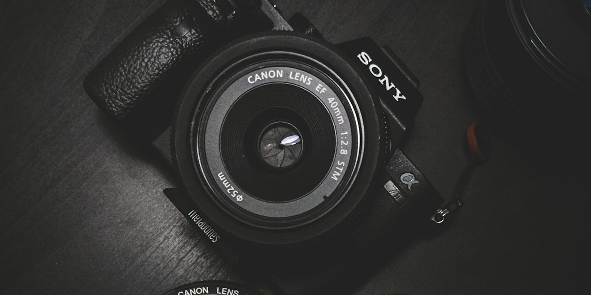 A camera body and lenses on a dark surface, representing free AI photo editing tools.
